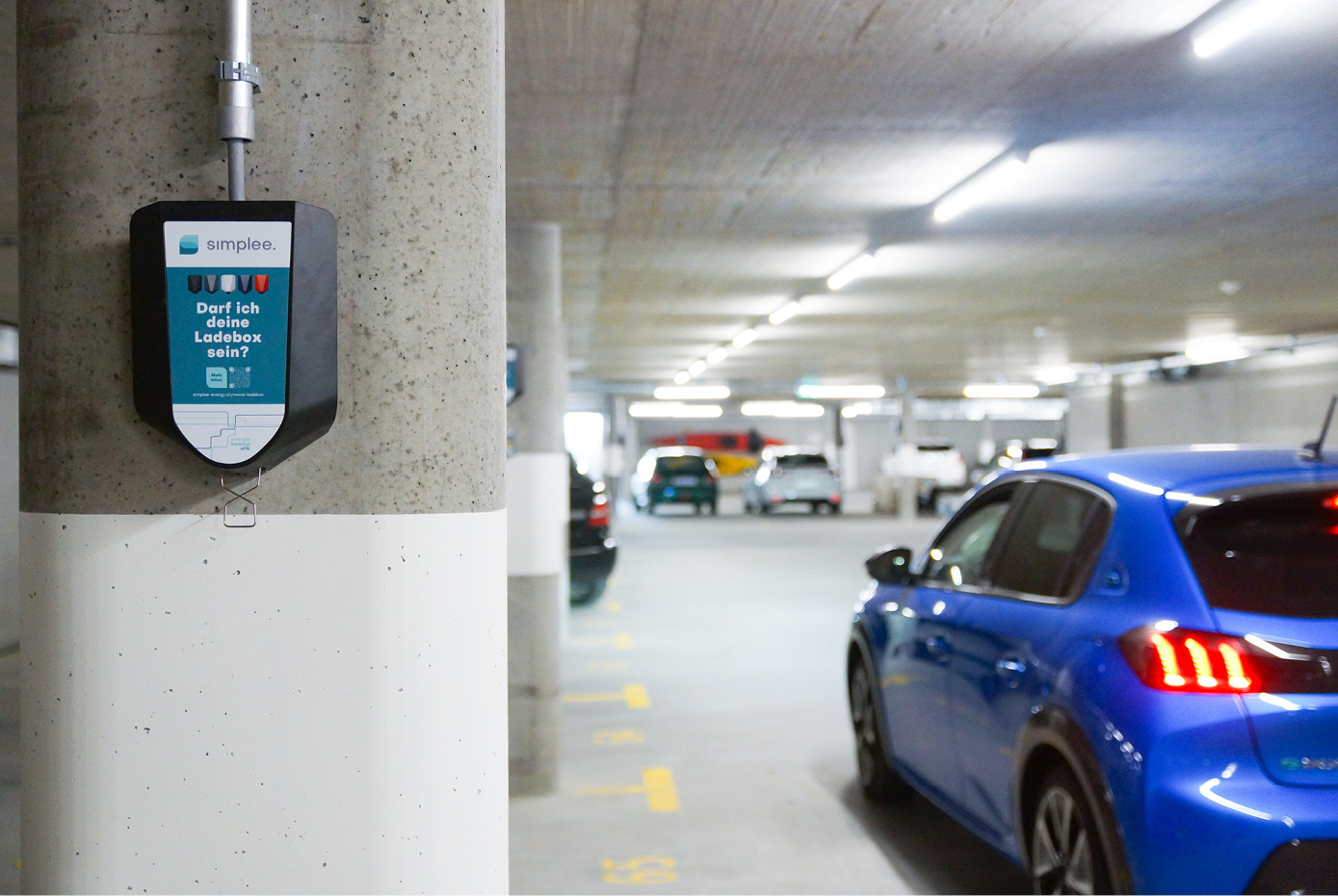 Ladestation in Tiefgarage mit parkiertem Elektroauto.