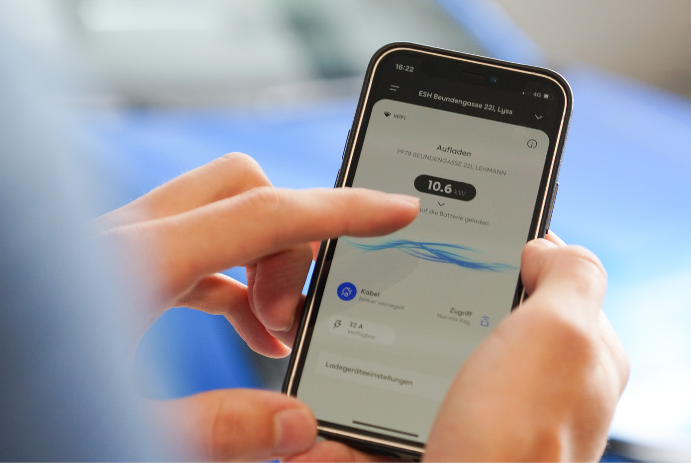 Person bedient E-Auto-Ladeapp auf dem Smartphone.