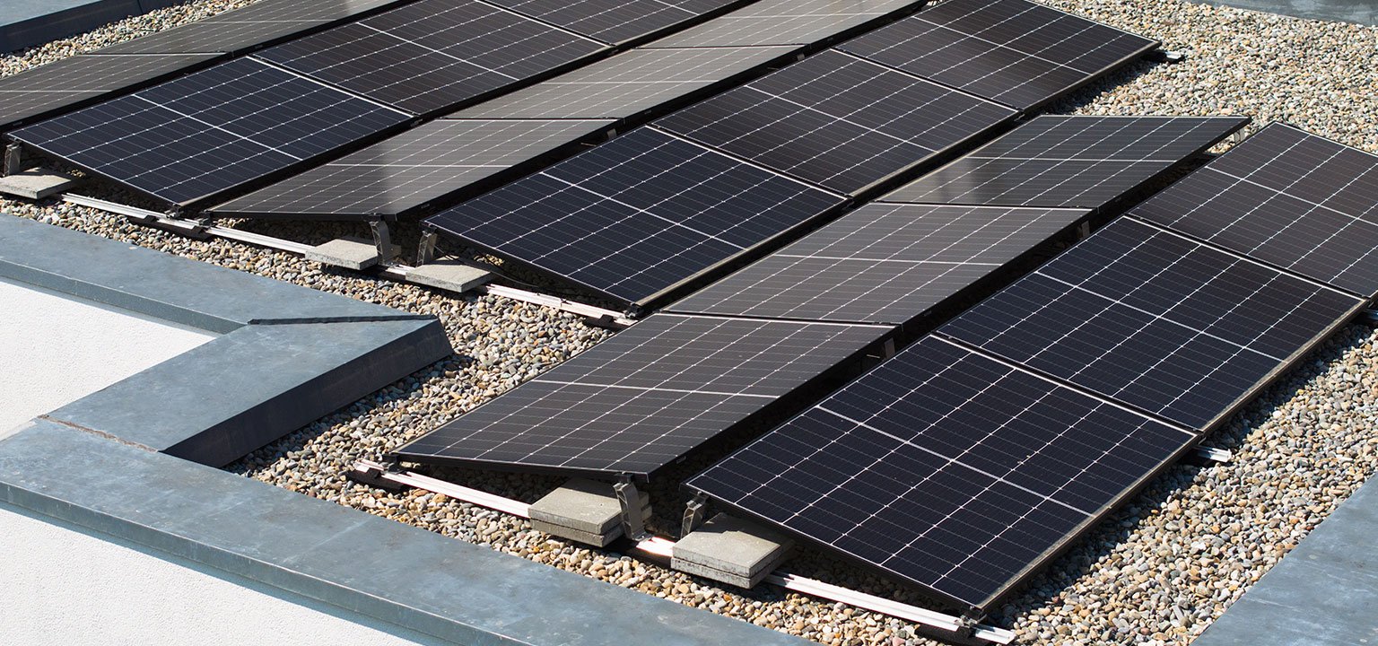 Solarmodule auf einem Flachdach bei Tageslicht.