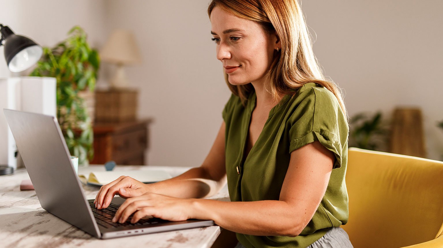 Frau arbeitet konzentriert am Laptop.