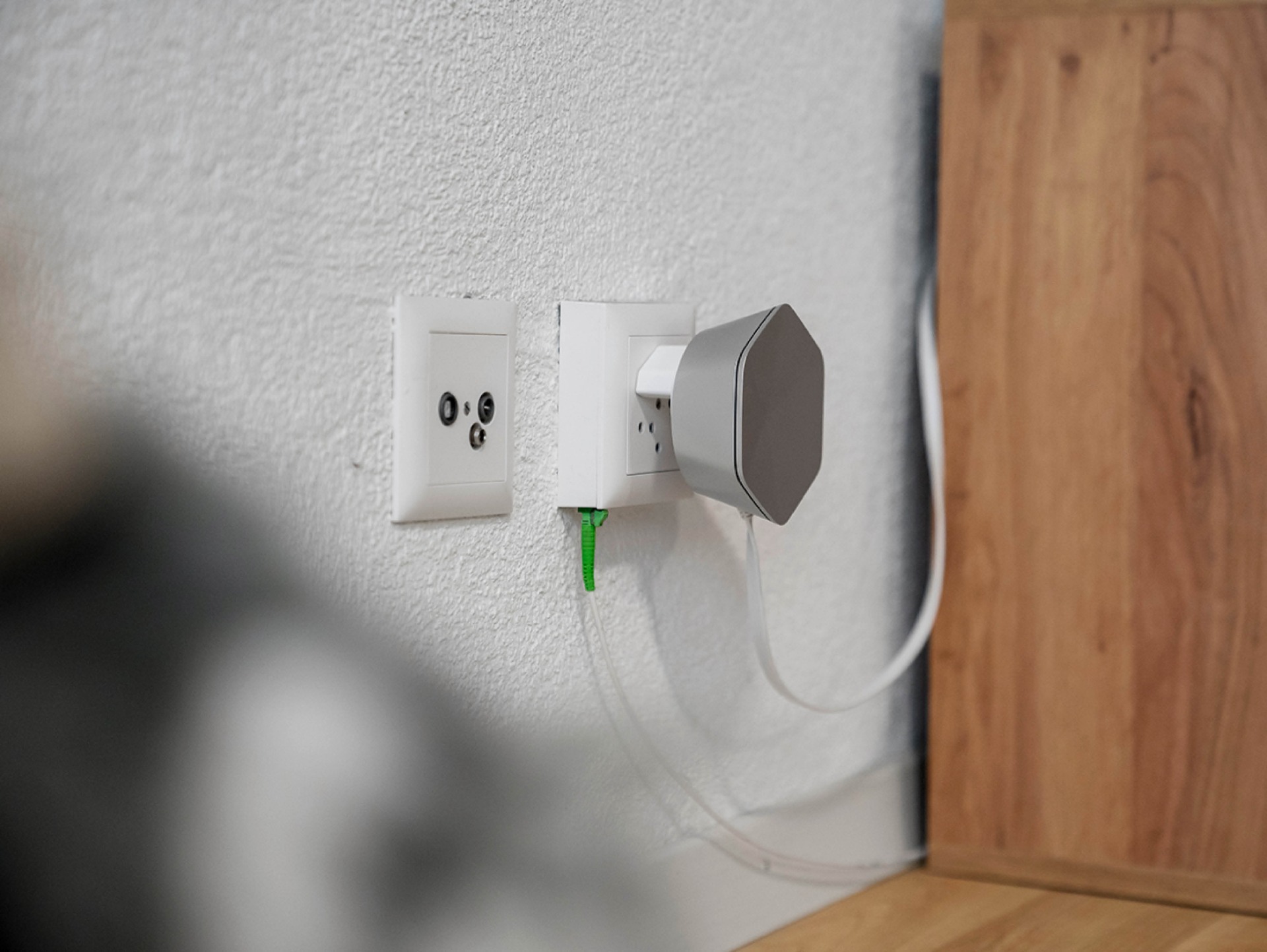 Glasfaseranschluss in moderner Wohnung mit installiertem Netzwerkgerät und sauber verlegten Kabeln.