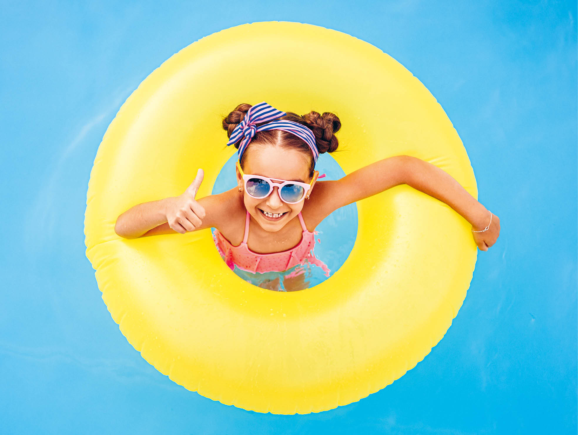 Kind mit Schwimmring im Wasser (Coverbild des Kundenmagazins Flow 1-26)