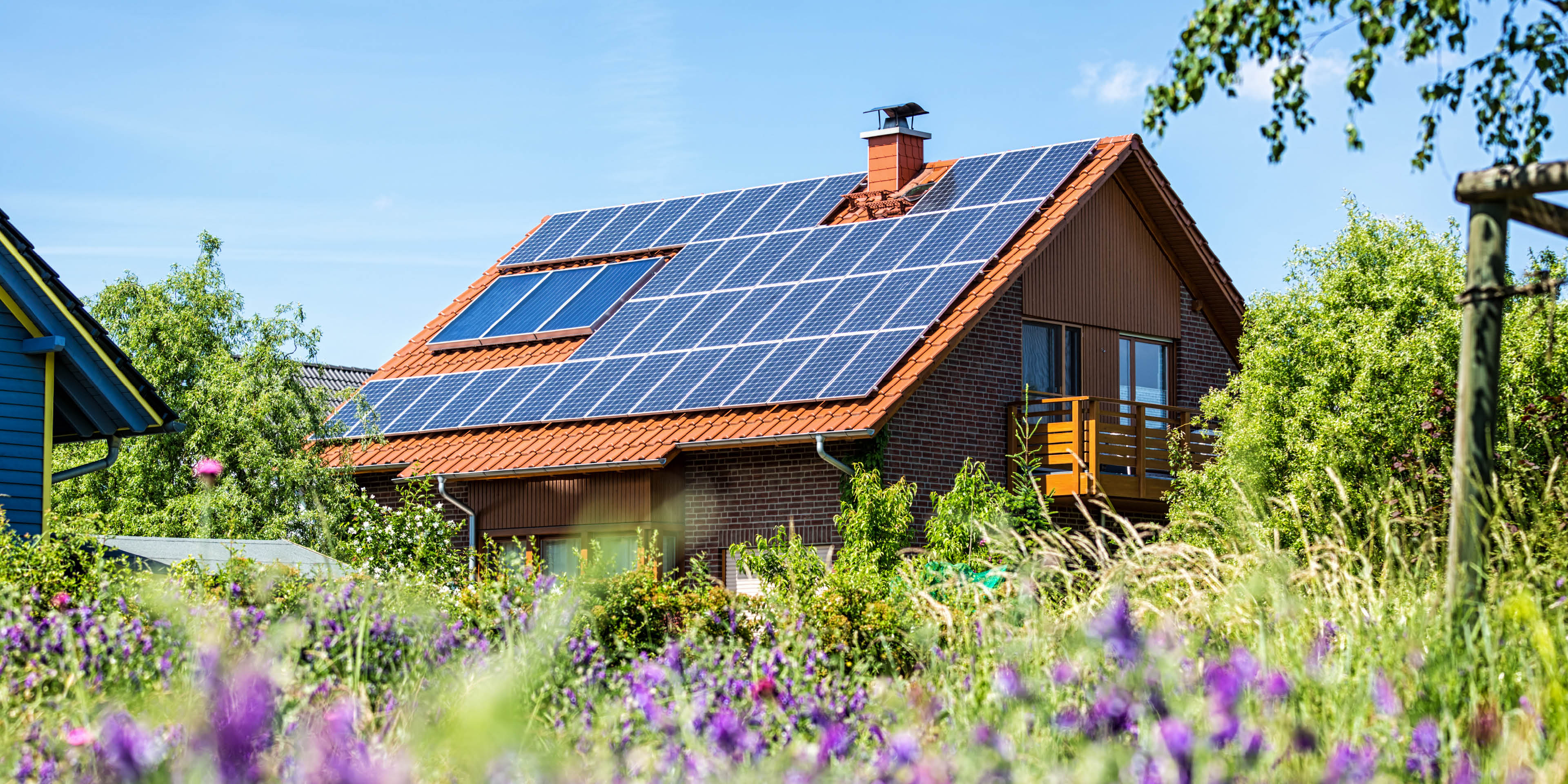 Einfamilienhaus mit Solaranlage auf dem Dach in einem Wohnquartier.