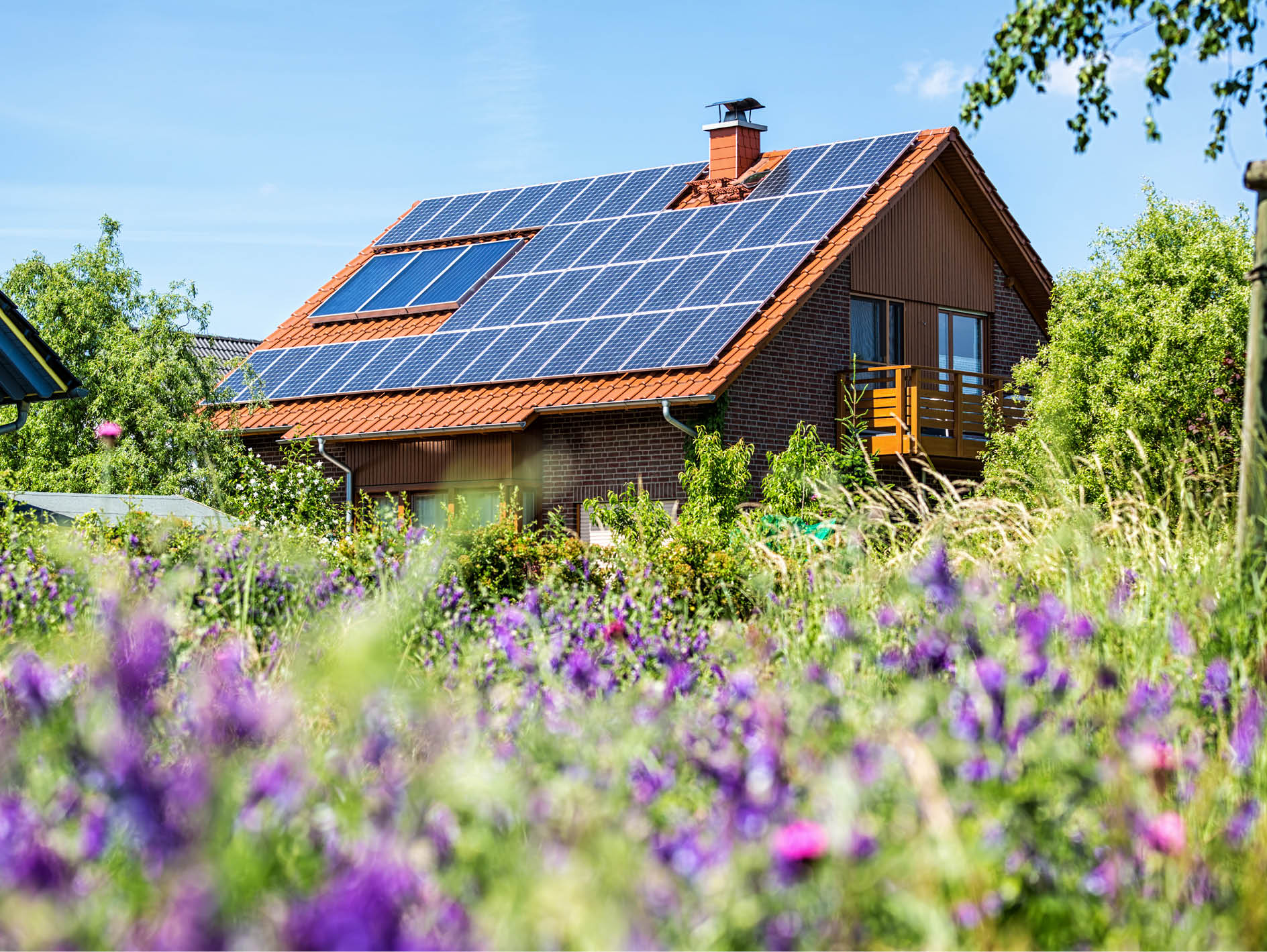 Einfamilienhaus mit Solaranlage auf dem Dach in einem Wohnquartier.