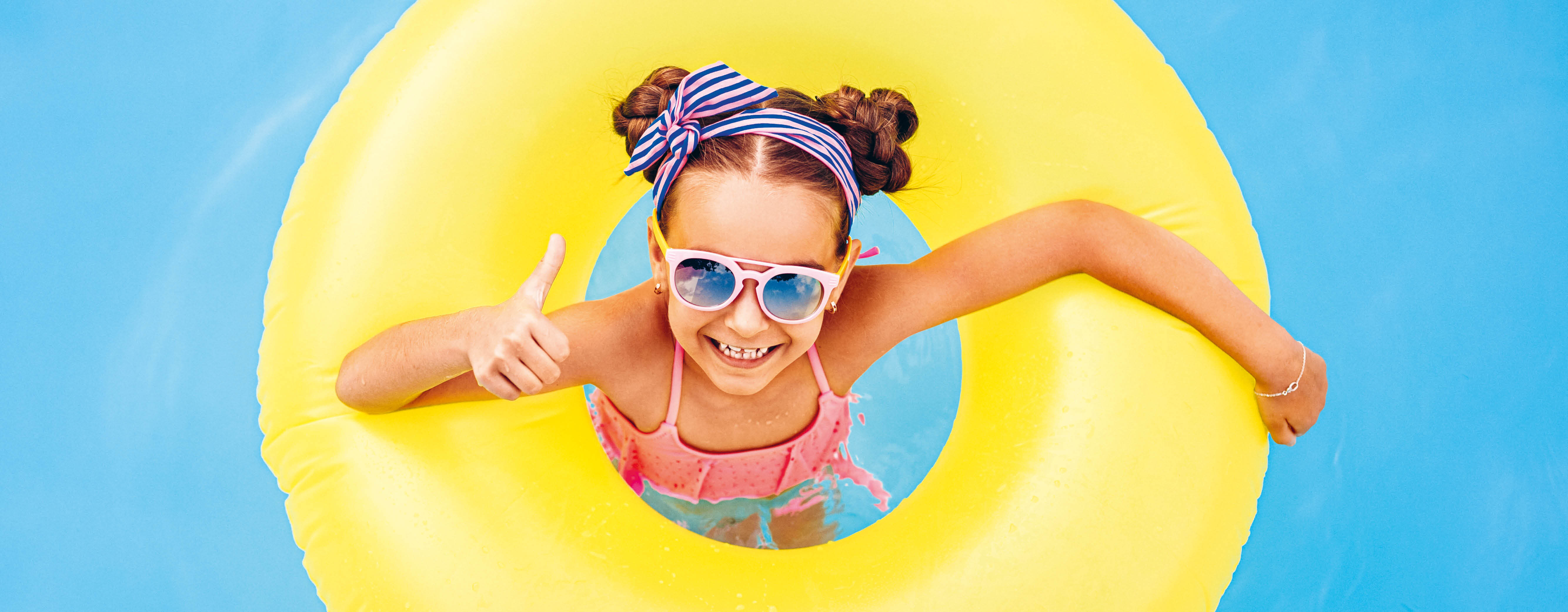 Kind mit Schwimmring im Wasser.