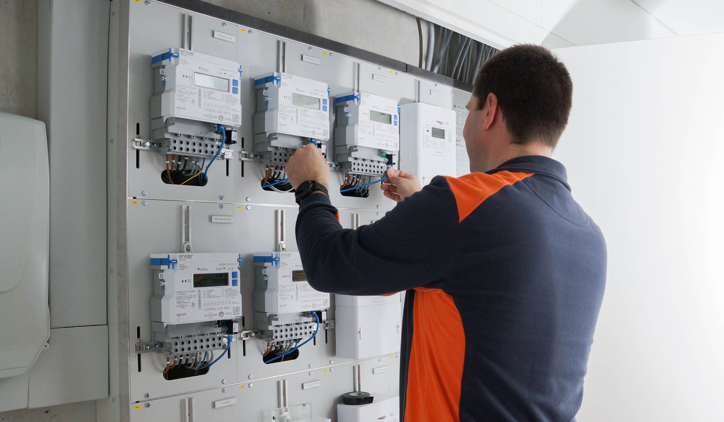 Fachperson installiert Smart Meter in einem Technikraum.