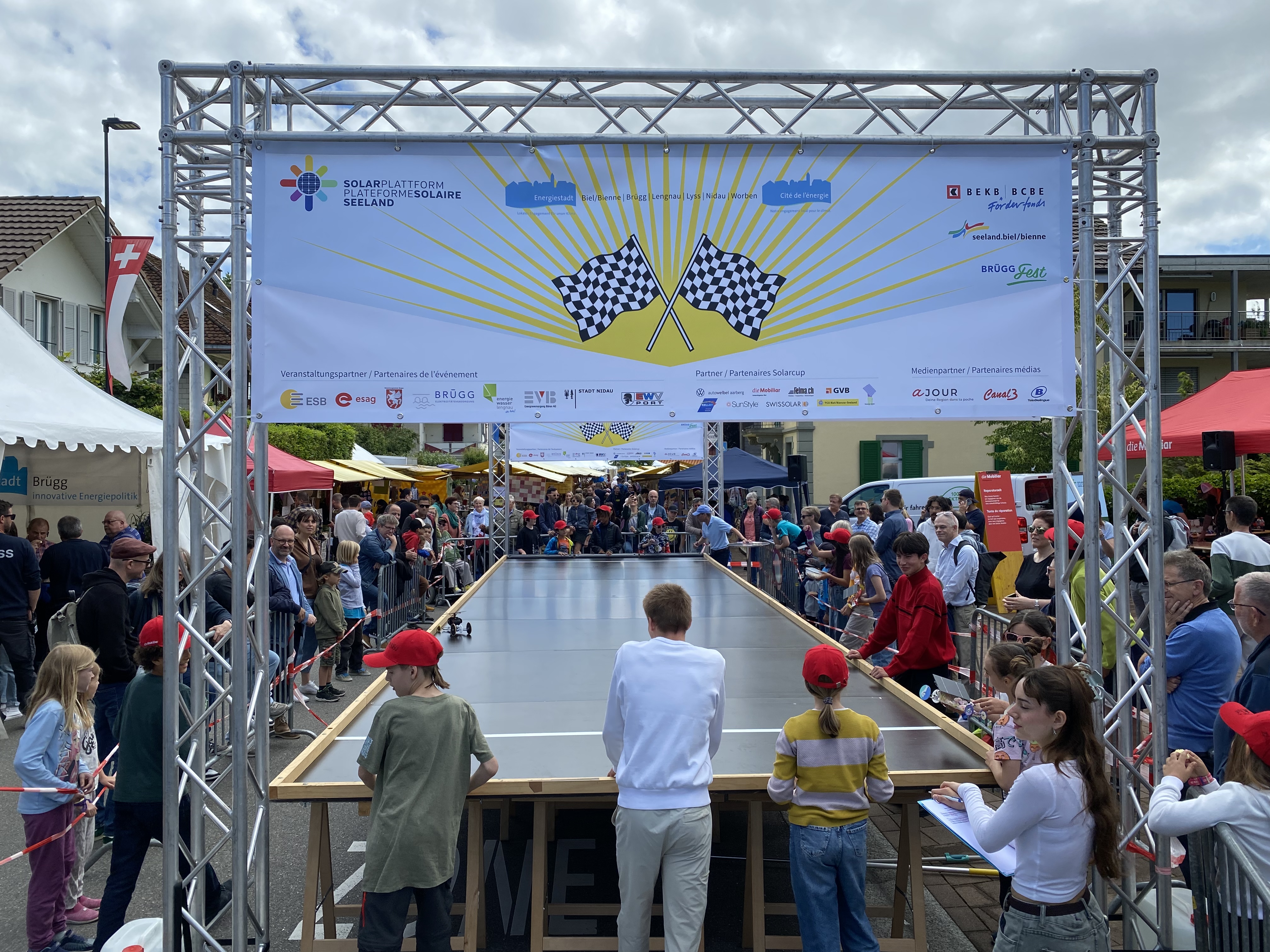 Rennbahn mit Zuschauenden beim Solarcup-Event im Freien.