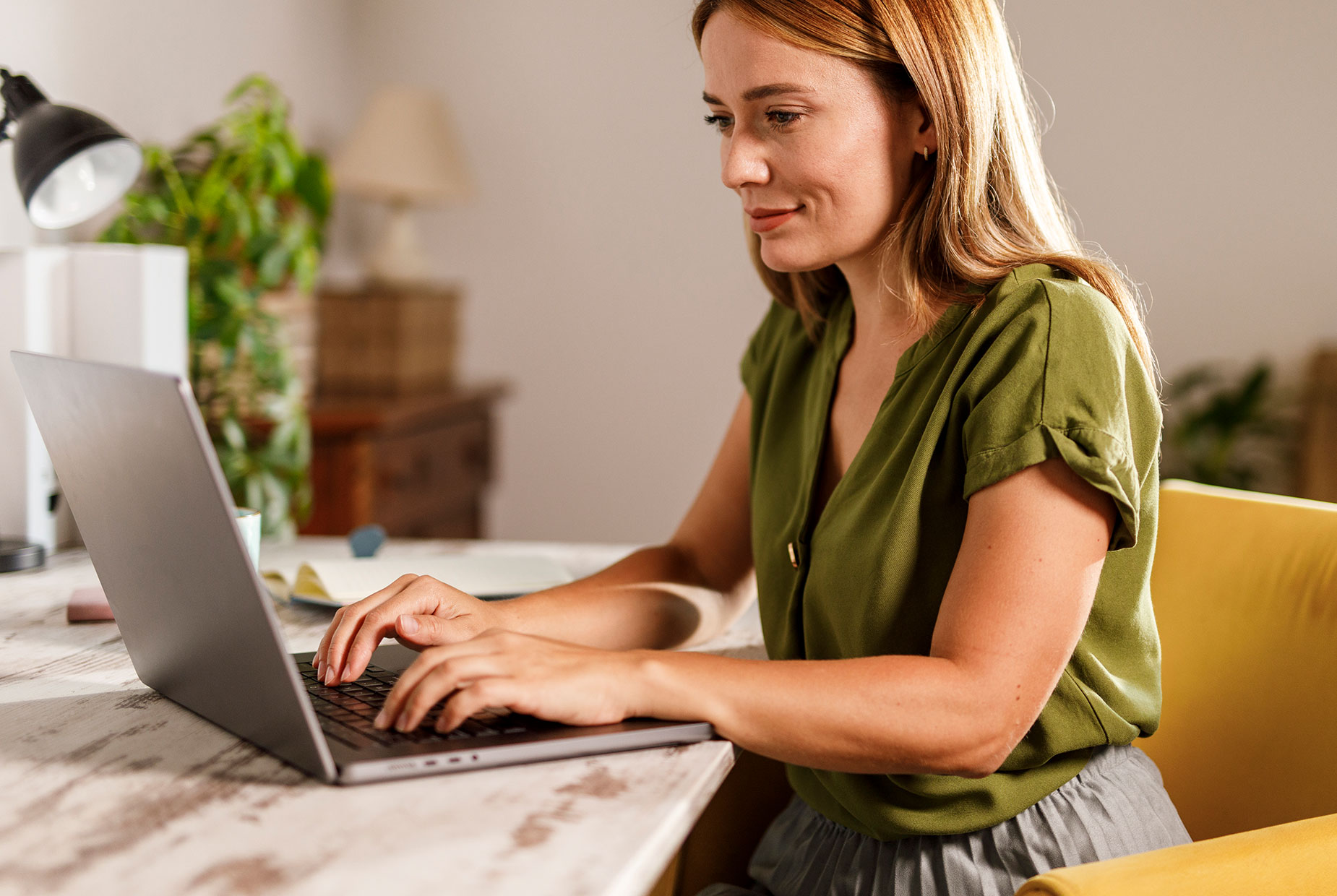 Frau arbeitet konzentriert am Laptop.